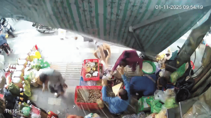 Thợ sơn cùng thùng sơn rơi từ trên cao xuống, trúng 2 người đứng trên vỉa hè. Ảnh cắt từ clip