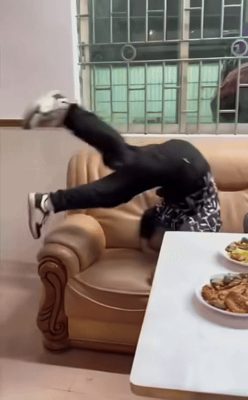 Trong lúc thực hiện động tác lộn nhào, cậu bé đã khiến cả bàn thức ăn đổ sập xuống. Ảnh cắt từ clip