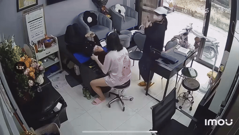 Người phụ nữ tiếp cận chiếc điện thoại của chủ tiệm, đồng thời quan sát camera trong tiệm. Ảnh cắt từ clip