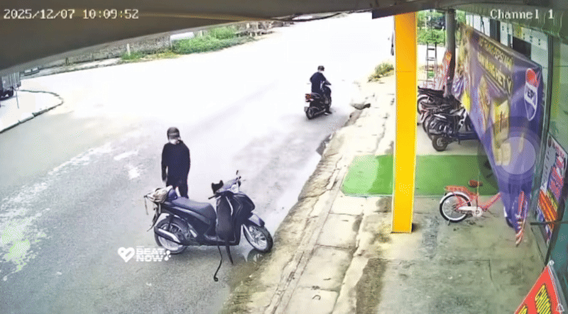 Nam thanh niên tiếp cận chiếc xe máy, bị con chó trên xe nhảy ra tấn công. Ảnh cắt từ clip