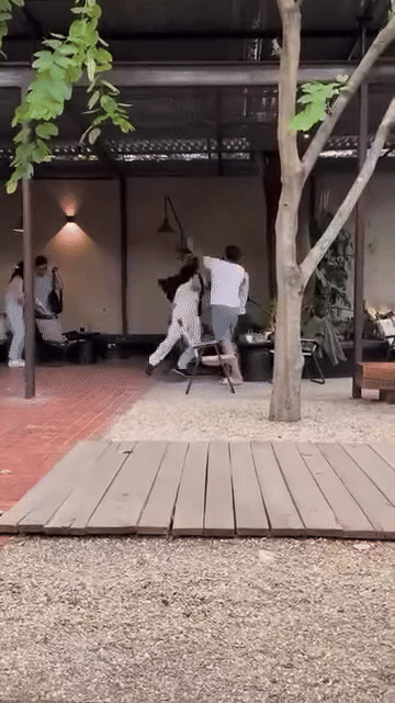 Người đàn ông mặc đồ màu trắng được cho có phong cách ăn mặc giống với 'vua cà phê' Đặng Lê Nguyên Vũ. Ảnh cắt từ clip