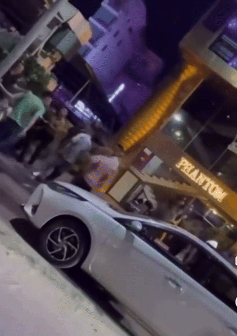 Cô gái áo trắng bị nhóm người đàn ông quây đánh.