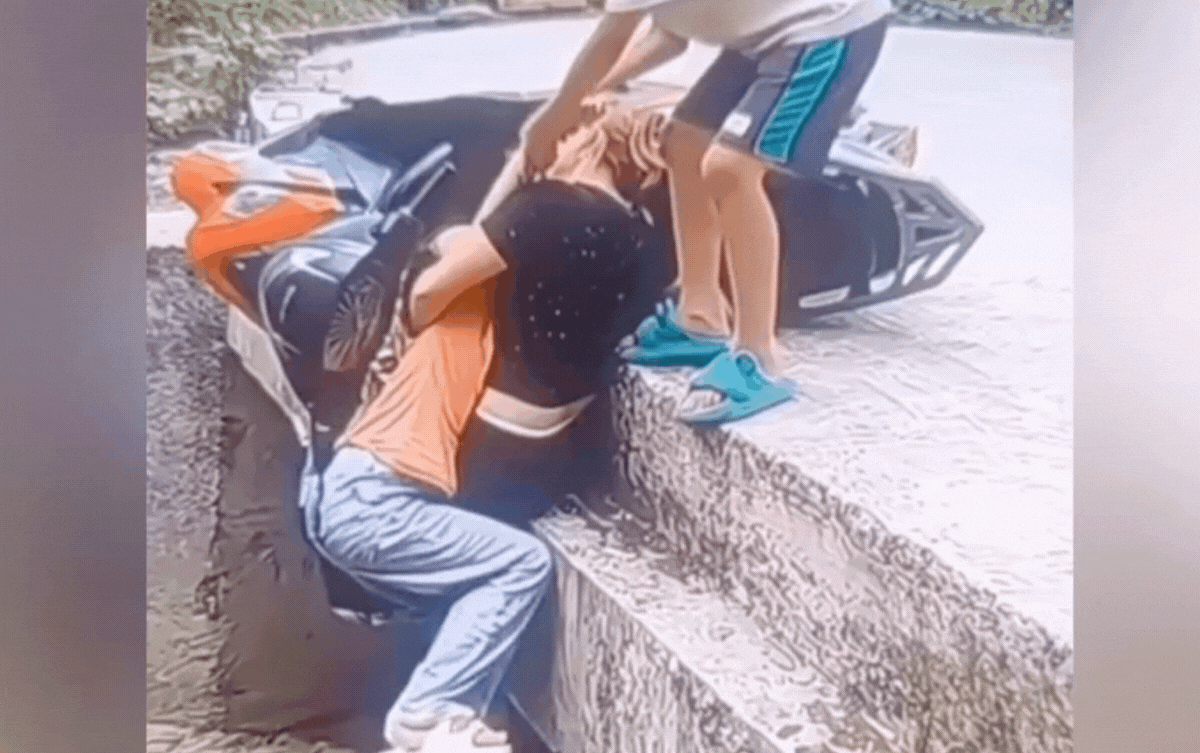 Người mẹ ôm chặt con vào lòng để không bị rơi xuống hố