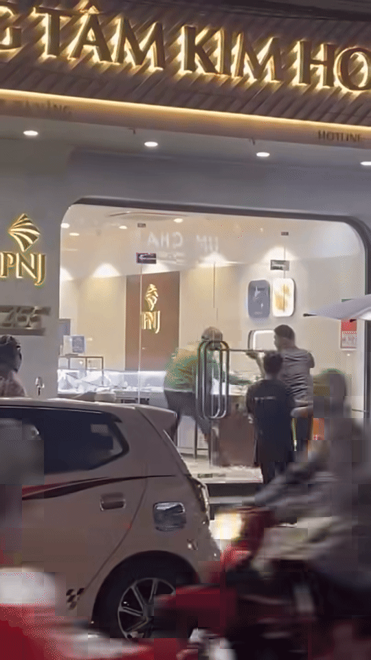 Nam thanh niên mặc áo Grab xông vào cướp tiệm vàng. Ảnh cắt từ clip