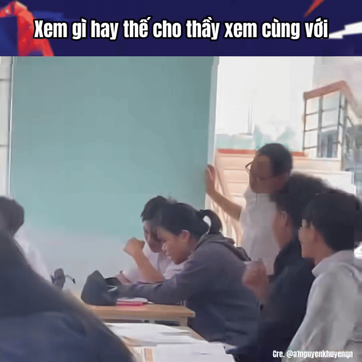 Cặp đôi học sinh lén lút xem điện thoại nhưng lại không hay biết rằng, thầy giám thị đang đứng đằng sau mình. Ảnh cắt từ clip