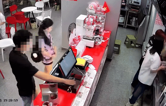 Người đàn ông nhanh tay lấy điện thoại rồi nhét vội vào túi mình. Ảnh được camera an ninh ghi lại.