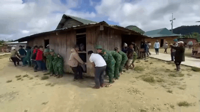 Bộ đội Đà Nẵng giúp dân khiêng 6 ngôi nhà rời khỏi vùng sạt lở. Ảnh cắt từ clip. (Nguồn: VTC News)