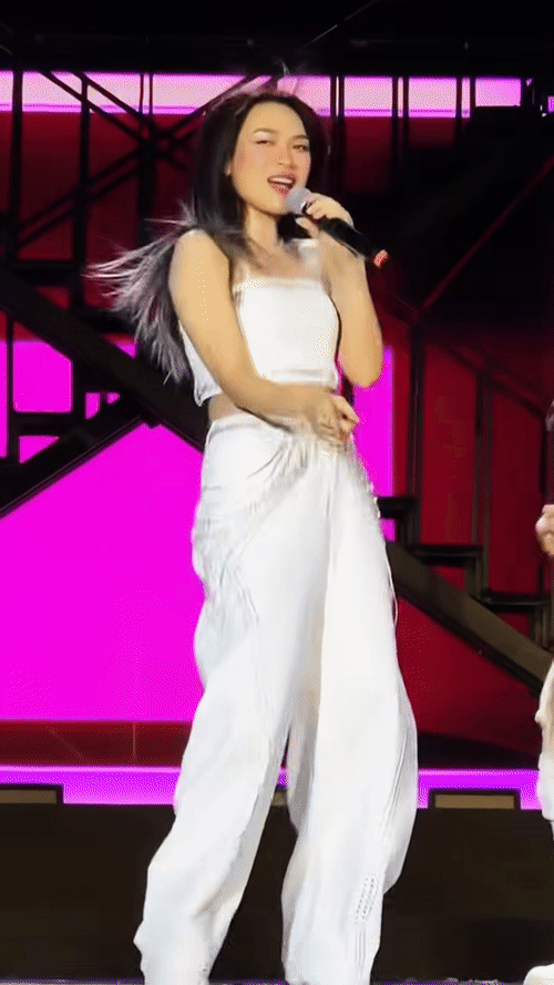 Hình ảnh nữ ca sĩ năng động, trẻ trung khi biểu diễn trên sân khấu.