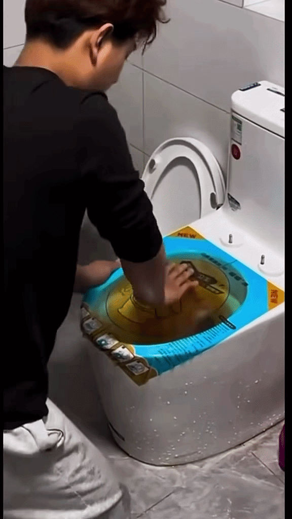 Hình ảnh đáng chú ý của nam thanh niên khi xử lý việc thông tắc bồn cầu. Ảnh cắt từ clip/ Nguồn: Page Hóng Đường Phố