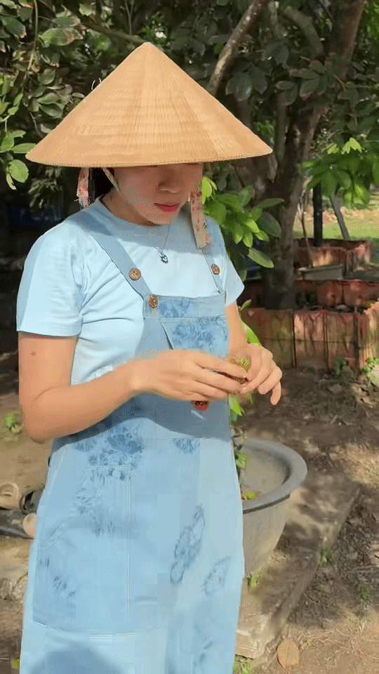 Ca sĩ Mỹ Tâm thích thú bóc chôm chôm ăn ngay tại vườn. Ảnh cắt từ clip