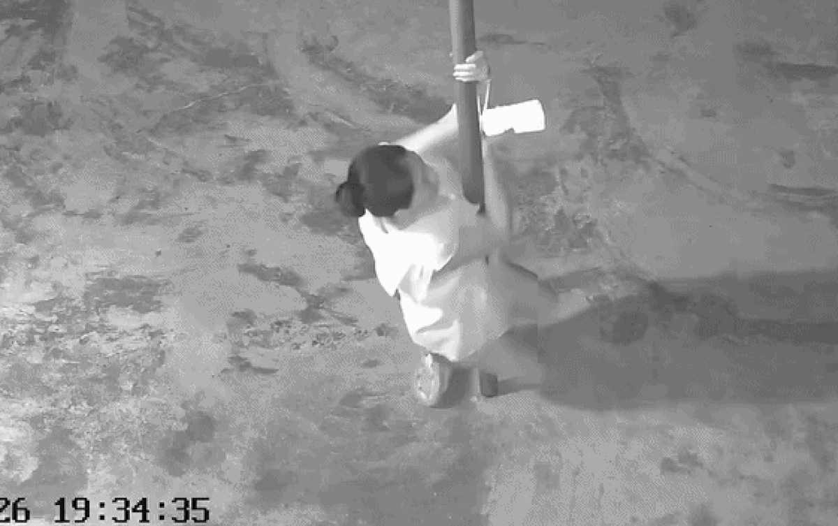 Cô gái quắp chân vào cây cột sau đó không thể đứng lên nữa. Ảnh cắt từ clip