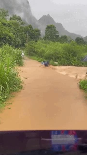 Hai thanh niên dắt xe máy qua dòng nước xiết, cái kết khiến ai nấy cũng 'xám mặt' Ảnh 1