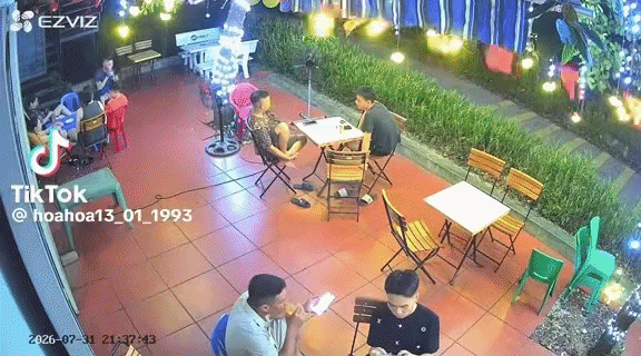 Đang ngồi uống cà phê, quả mít rơi vào trúng vòng tay của người đàn ông. Ảnh cắt từ clip
