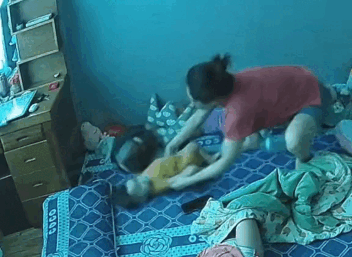 Thấy con rắn đang ngọ nguậy ở ngay trên đầu con gái nhỏ, người mẹ vội bế thốc con gái ra nơi an toàn. Ảnh cắt từ clip