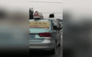 Nữ sinh ngồi vắt vẻo trên cửa xe taxi để làm bài tập