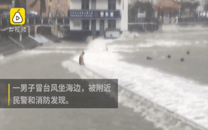 Người đàn ông Trung Quốc bị sóng đánh lật người vẫn cố chấp không rời đi trong bão Mangkhut