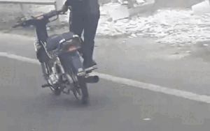 Clip nam thanh niên đầu trần, đứng hẳn về một bên vừa lái xe vừa lạng lách đánh võng giữa quốc lộ khiến nhiều người ngao ngán