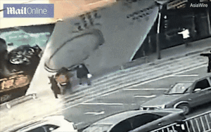 Đang đi đường bất ngờ bị bảng hiệu khổng lồ đổ sập vào người