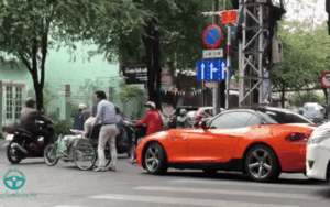 Tài xế BMW dừng xe đưa cụ ông ngồi xe lăn sang đường và thái độ gây chú ý của tài xế ô tô dừng đợi phía sau