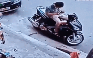 Hãi hùng clip nam thanh niên đang ngồi nạp thẻ điện thoại bị ô tô 5 chỗ húc văng xuống đường