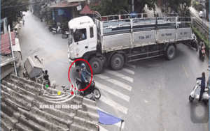Giật mình cảnh chiếc xe tải đang chầm chậm ôm cua, bất ngờ một phụ nữ chạy ra nằm ngay bánh xe