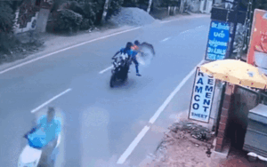 Ngồi trên xe máy còn cầm ô, người phụ nữ bị gió thổi bay xuống đường