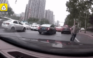 Đang dừng xe chờ đèn đỏ, tài xế hoảng hốt khi bị người đàn ông lạ nhảy lên mui xe hòng ăn vạ