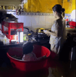 Nghẹn lòng hình ảnh người mẹ đặt con vào chậu, vừa trông vừa nấu vội bữa cơm chiều giữa nước lũ