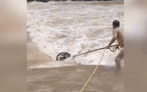 Người đàn ông lao ra dòng lũ dữ, liều mình cứu chàng trai bị cuốn trôi