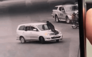 Kinh hãi cảnh nữ tài xế vẫn chạy xe băng băng trên đường Hà Nội bất chấp lái xe taxi đu bám trên nắp capo