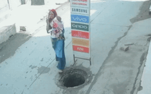 Mải nghe điện thoại, người mẹ bế con nhỏ hụt chân rơi xuống cống