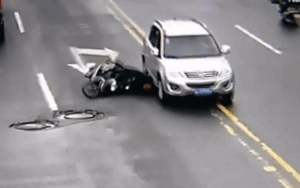 Clip: Hết ngã xe máy đến bị ô tô chèn qua đầu, người đàn ông vẫn thản nhiên bò dậy