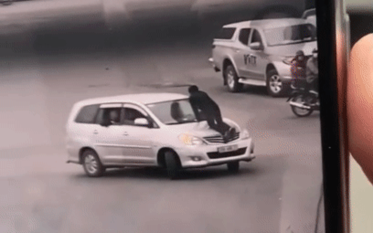 Kinh hãi cảnh nữ tài xế vẫn chạy xe băng băng trên đường Hà Nội bất chấp lái xe taxi đu bám trên nắp capo Ảnh 2