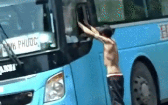 Clip: Người đàn ông dựng xe máy giữa đường rồi cầm gạch đập vỡ kính, đu lên xe khách để đánh tài xế Ảnh 2