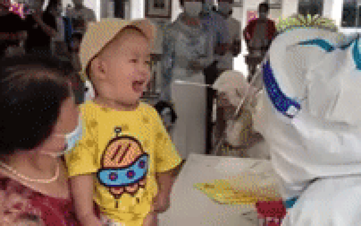 Em bé tỏ vẻ hoảng hốt khi lấy dịch họng, nữ nhân viên y tế liền có hành động khéo léo xua tan đi nỗi sợ Ảnh 2