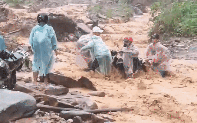 Thót tim theo dõi cảnh nhóm người chật vật dắt xe máy vượt qua dòng lũ đục ngầu đang chảy xiết Ảnh 2