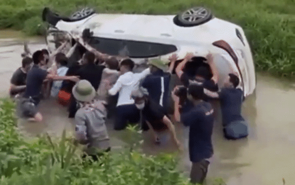 Clip: 20 người dân hợp sức giải cứu xe ô tô bị lật úp dưới mương nước Ảnh 2