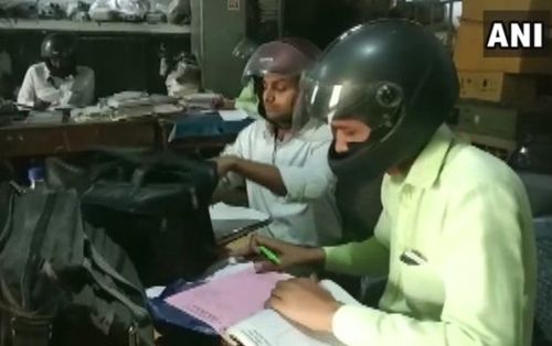 Sợ nhà sập bất cứ lúc nào, nhân viên đội mũ bảo hiểm khi làm việc