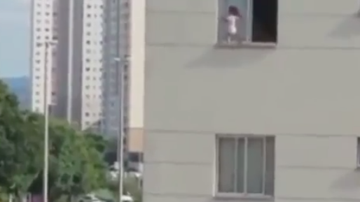 'Thót tim' cảnh em bé cheo leo trên cửa sổ chung cư