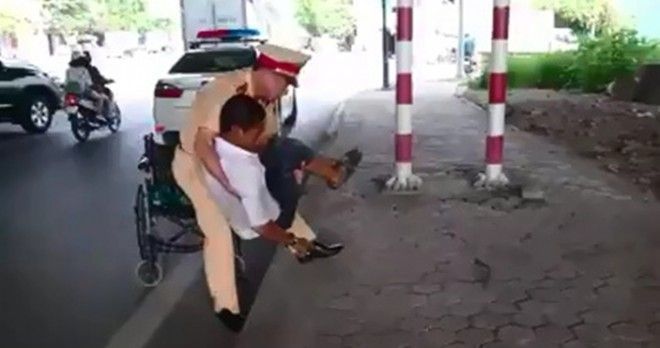 Xúc động hình ảnh người cảnh sát bế người ngồi xe lăn gặp tai nạn