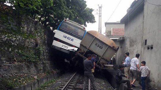 Tàu hỏa chèn xe khách chở công nhân 'lơ lửng' trên sườn đồi