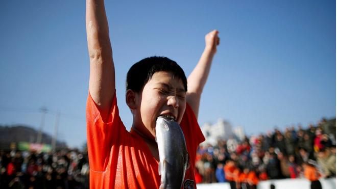 Cắn cá hồi ngay khi bắt dưới sông băng giữa trời lạnh thấu xương