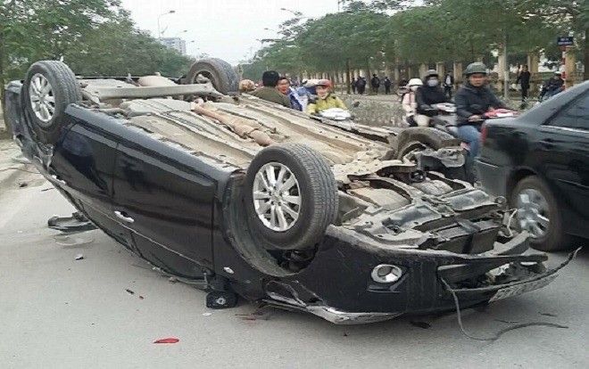 Ô tô mất lái đâm đổ cột đèn, lật ngửa giữa đường khiến tài xế bị gãy tay