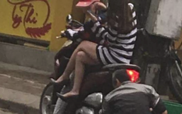 Cư dân mạng chê bai thiếu nữ mặc váy ngắn ngồi vắt vẻo trên xe khi bác thợ cặm cụi bơm lốp