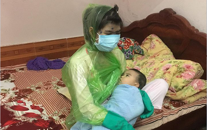 Hình ảnh mẹ trẻ bị thủy đậu phải trùm áo mưa kín mít cho con trai  bú sữa khiến cư dân mạng vừa thương vừa buồn cười