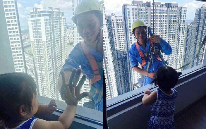 Hình ảnh người công nhân cheo leo trên tòa cao ốc nở nụ cười hiền với bé gái qua mặt kính gây xúc động mạnh