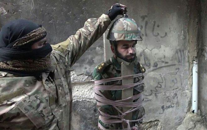 Phiến quân IS gắn bom lên đầu tù nhân rồi cho phát nổ