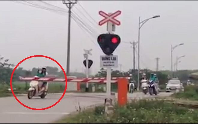 Bất chấp tử thần, đoàn xe ung dung băng qua đường ray đang có đèn cảnh báo