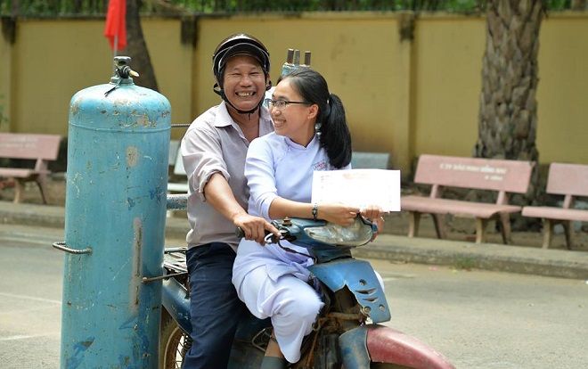 Xúc động hình ảnh ông bố đèo cả bình khí trên chiếc xe cũ kỹ tranh thủ đến trường dự lễ tổng kết năm học cùng con gái