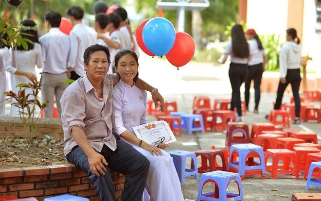 Nữ sinh trong bức ảnh 2 bố con dự lễ tổng kết năm học đang gây sốt : '10 năm nay, năm nào ba cũng cầm bóng bay đến chúc mừng con gái'